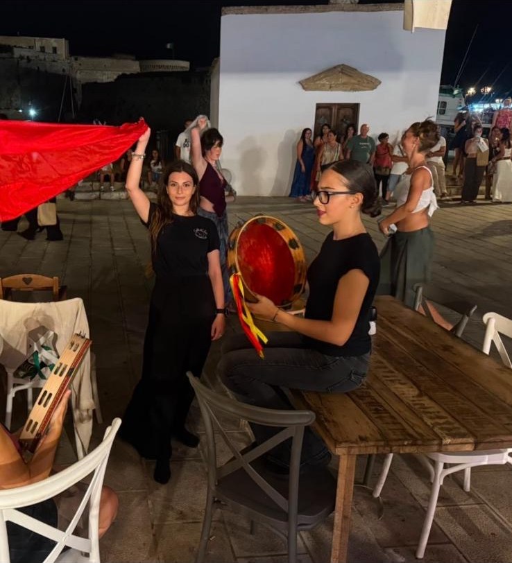 Ragazza dello staff Costa del Sud che suona il tamburello durante la serata di pizzica