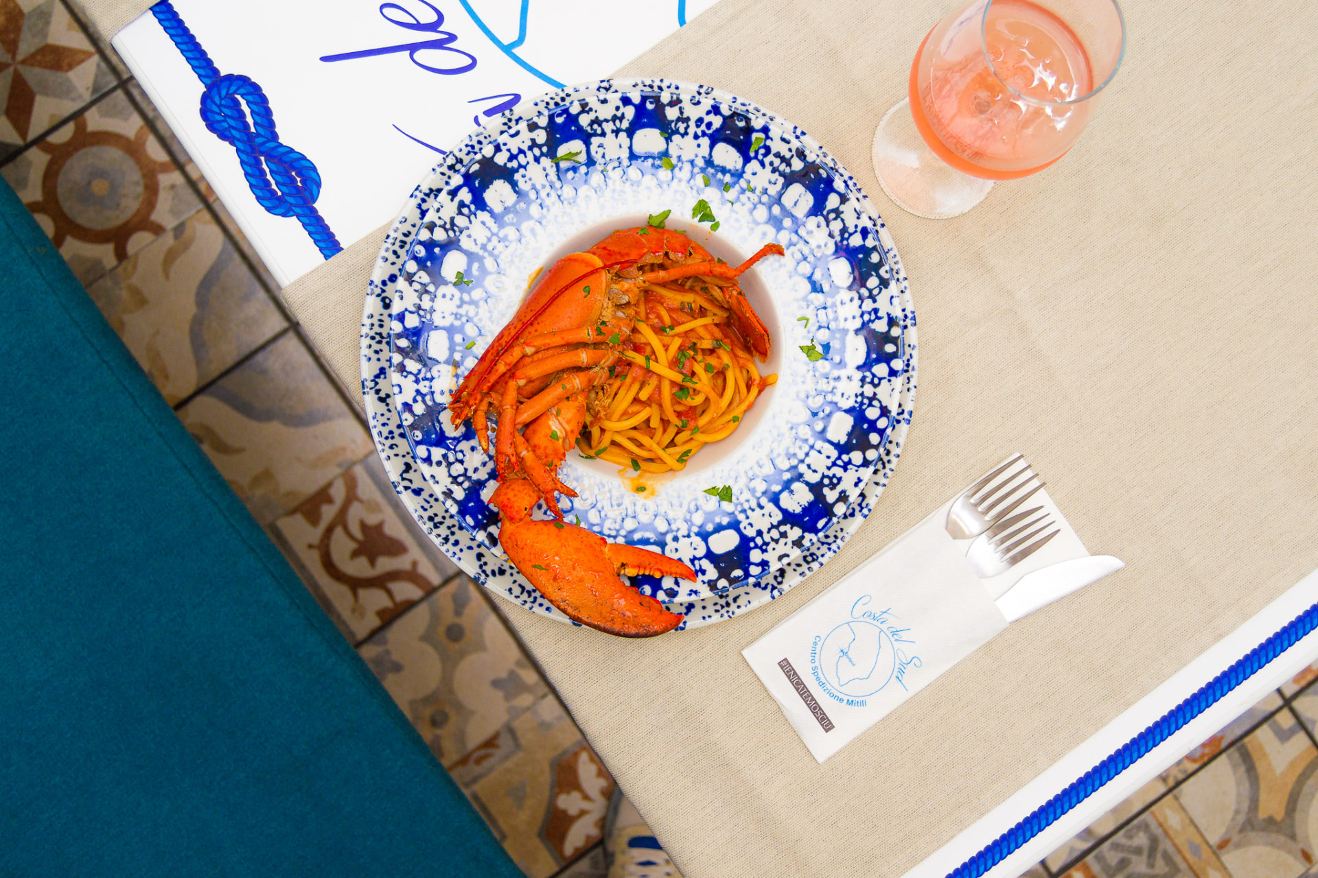 Spaghetti all'astice serviti su ceramica cobalto al Costa del Sud